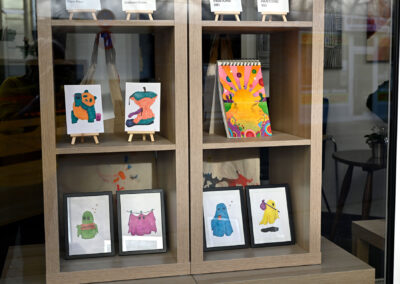Bunte Postkarten und kleine Kunstwerke im Schaufenster